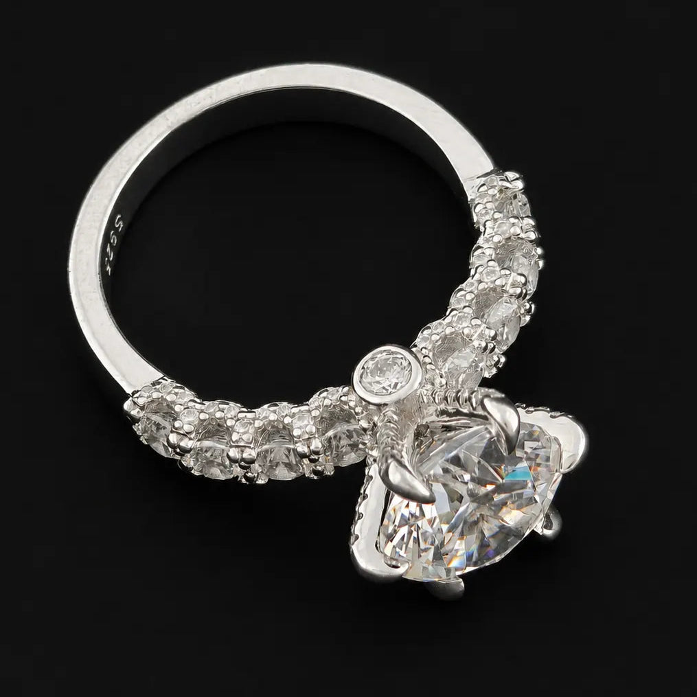 Side profile of round cut moissanite diamond ring displaying high setting and pave shoulder band