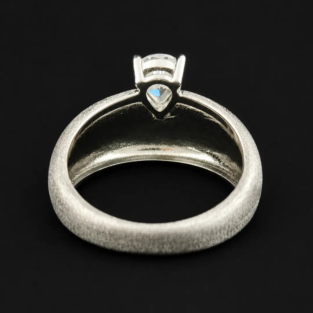 Underside profile of wide textured silver ring showing smooth interior comfort fit