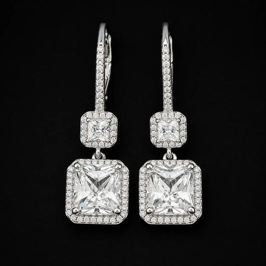 Woman wearing double radiant cut halo drop earrings with lever back closure.