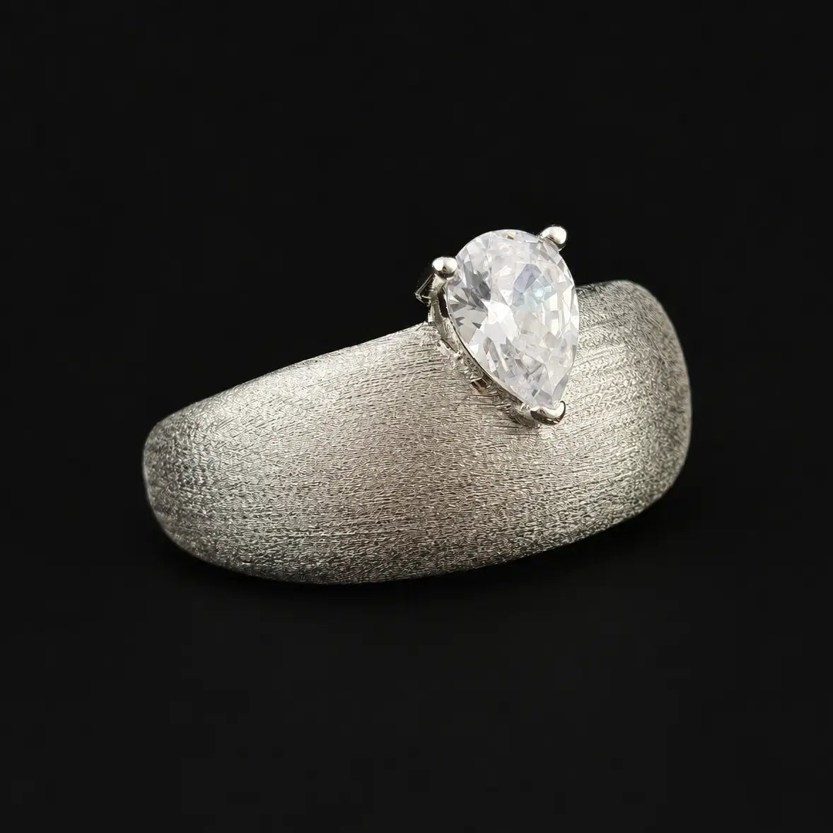 Front view of pear shape moissanite wide cigar band ring with satin texture