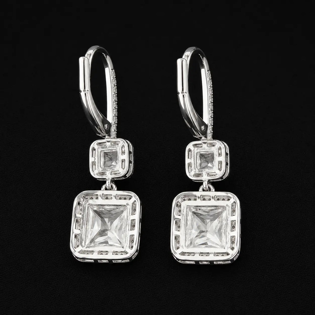 Rear view showing hollowed structural frame and leverback closure of silver halo drop earrings.